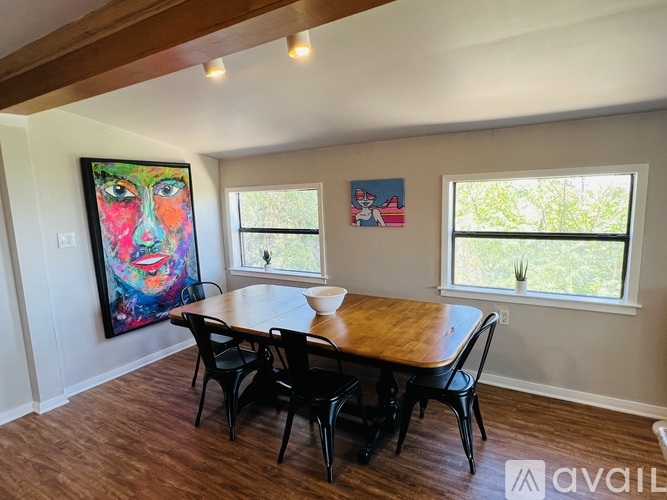A dining room with a wooden table and chairs.