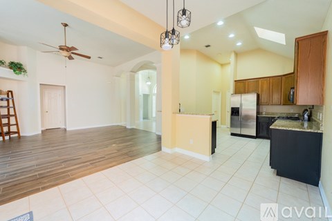 A kitchen with a black counter and wooden cabinets.