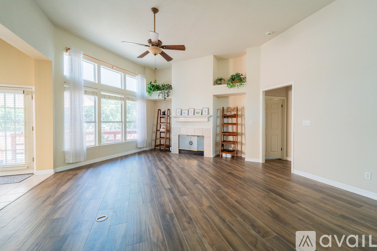 A spacious living room with wood flooring and a ceiling fan.