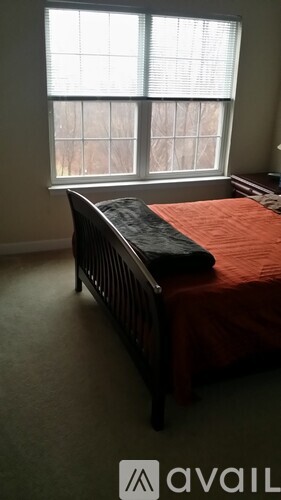 A bedroom with a bed and a window.
