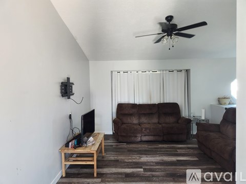 A living room with a brown couch and a wooden coffee table.