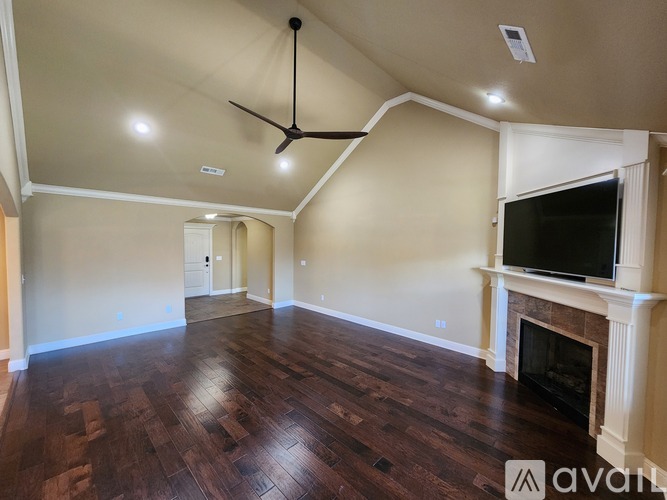 A spacious room with a fireplace and a television mounted above it.