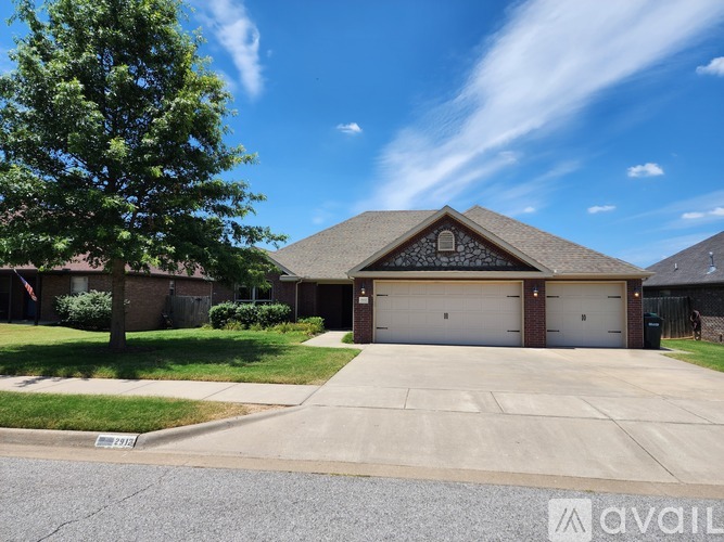 A house with a large front yard and a tree.