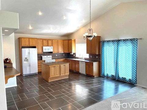 A kitchen with wooden cabinets and a tiled floor.