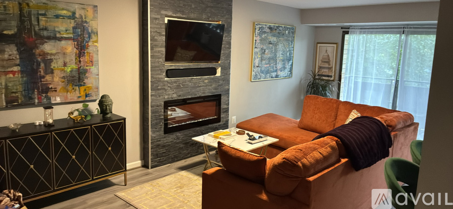 A living room with a fireplace and a painting on the wall.
