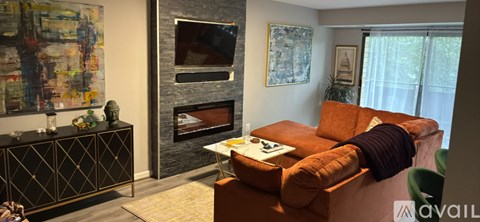 A living room with a fireplace and a painting on the wall.