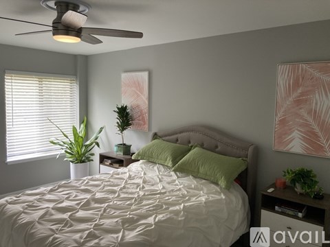 A bedroom with a large bed and a ceiling fan.
