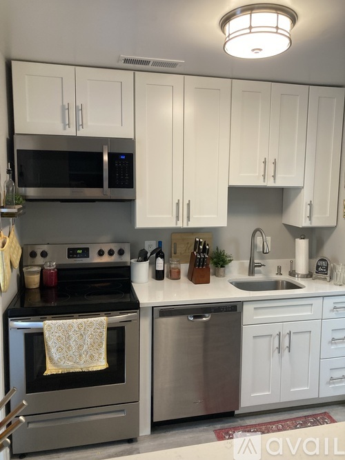A kitchen with white cabinets and a stainless steel oven.