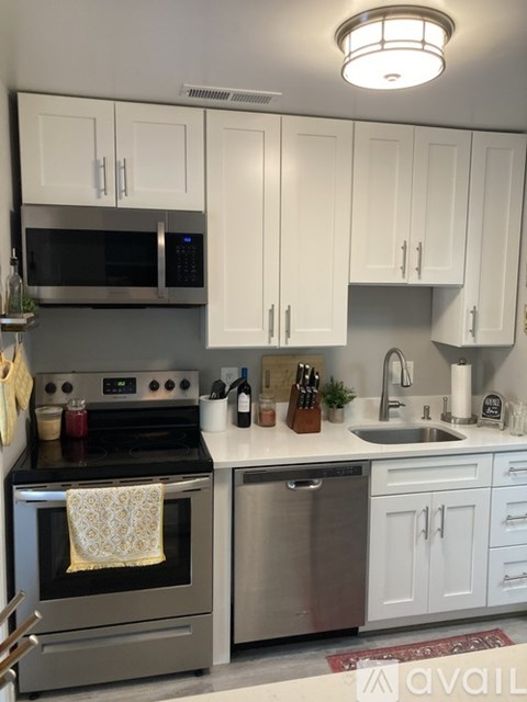 A kitchen with white cabinets and a stainless steel oven.