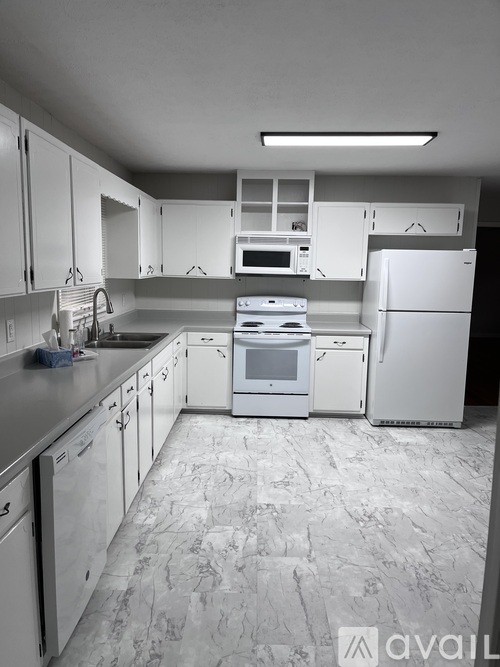 A kitchen with white appliances and cabinets.