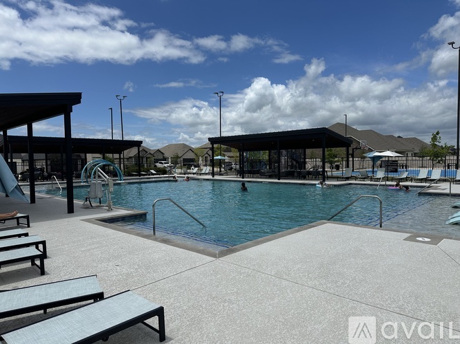 A large outdoor swimming pool with a slide and sun loungers.