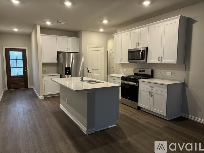 A kitchen with white cabinets and a large island.