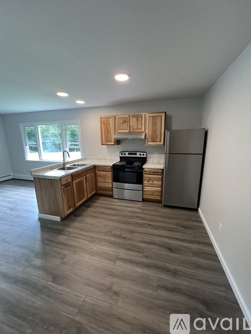 A kitchen with wooden cabinets and a refrigerator.