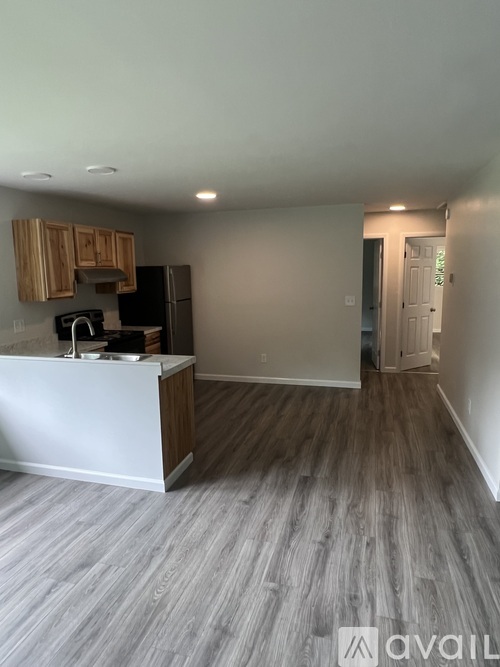 A kitchen with a white counter and wooden cabinets.
