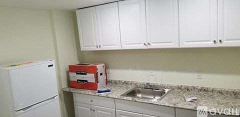 A kitchen with white cabinets and a granite countertop.