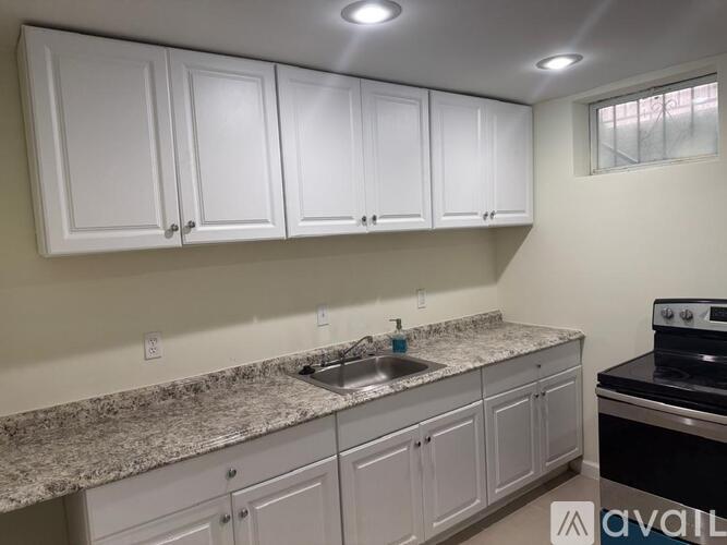 A kitchen with white cabinets and granite countertops.