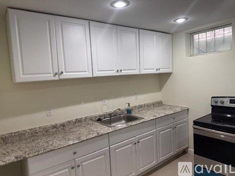 A kitchen with white cabinets and granite countertops.