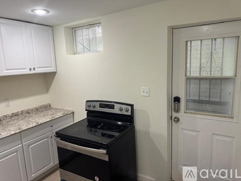 A kitchen with a black stove top oven and white cabinets.