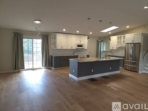 A spacious kitchen with wooden floors and modern appliances.