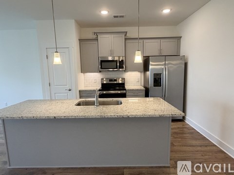 A kitchen with a granite countertop and stainless steel appliances.