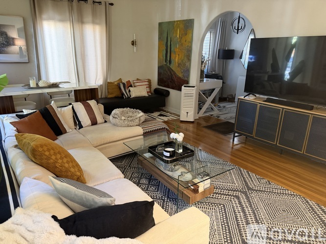 A living room with a white couch and a coffee table in front of it.