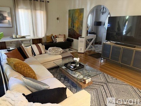 A living room with a white couch and a coffee table in front of it.