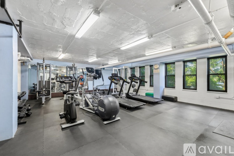 A gym with a variety of equipment including treadmills, weights, and exercise machines.
