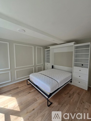 A bedroom with a bed, drawers, and a wardrobe.