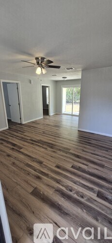 A room with wooden flooring and a ceiling fan.