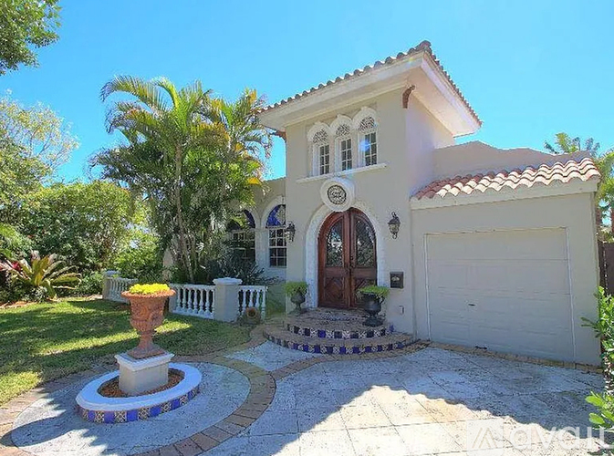 A house with a white fence and a brown door.
