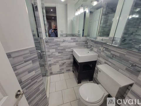 A bathroom with a toilet, sink, and mirror.