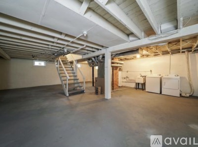 A spacious garage with a staircase and a washing machine.