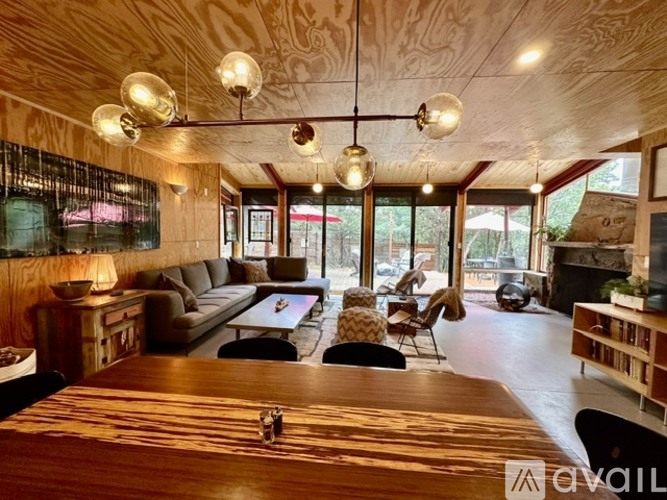 A living room with a wooden floor and ceiling, a sofa set, a coffee table, and a fireplace.