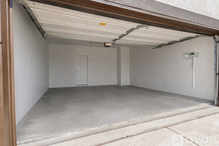 A spacious garage with a white door and a concrete floor.
