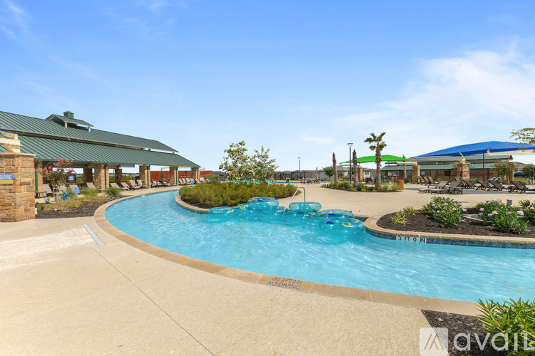 A large outdoor swimming pool with a concrete walkway around it.