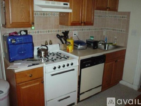 A kitchen with a white stove top and wooden cabinets.