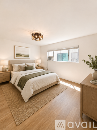 A bedroom with a large bed and a wooden floor.