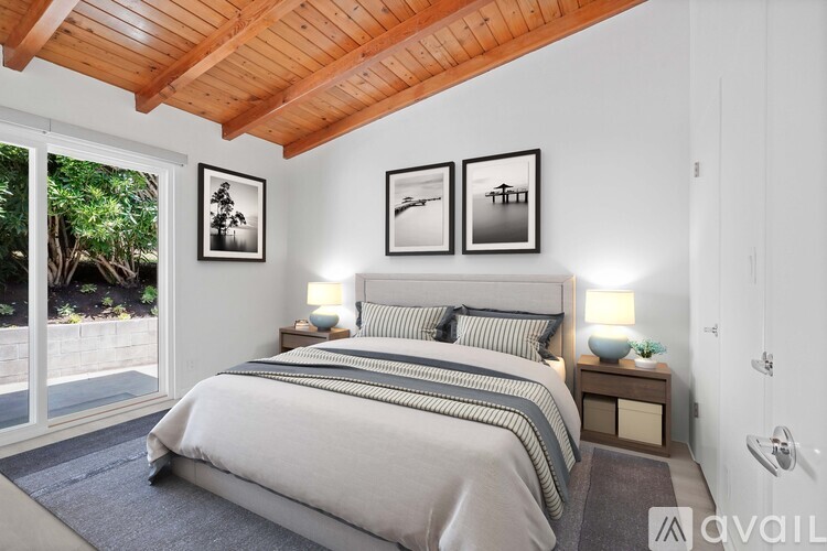 A bedroom with a large bed and a wooden ceiling.
