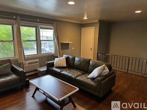 A living room with a brown leather couch and a coffee table.