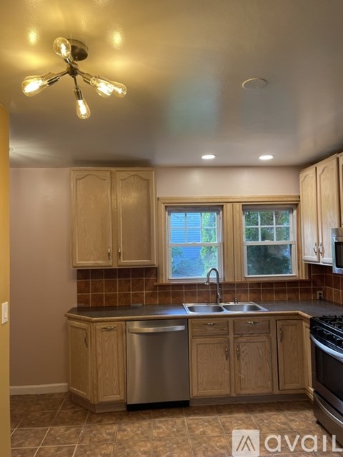 A kitchen with wooden cabinets and a stainless steel sink.