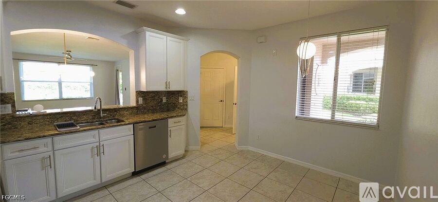 A kitchen with white cabinets and a granite countertop.