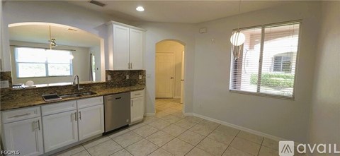 A kitchen with white cabinets and a granite countertop.