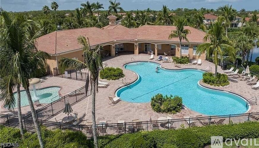 A large house with a pool and palm trees.