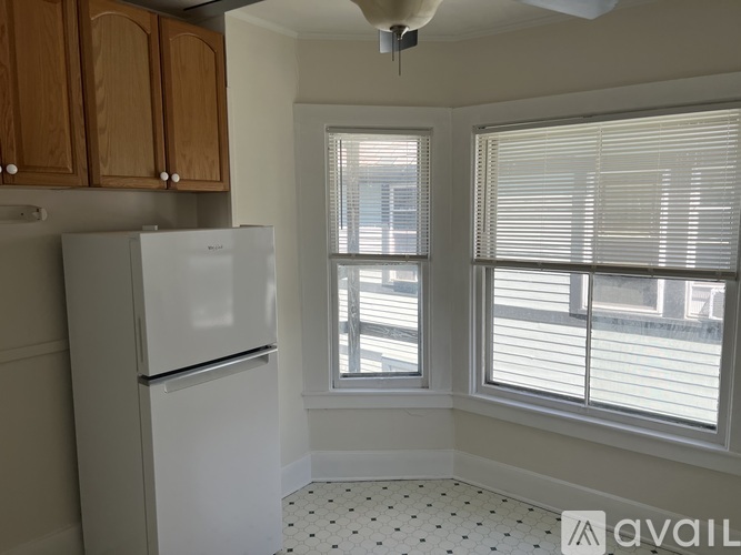 A kitchen with a white fridge and wooden cabinets.