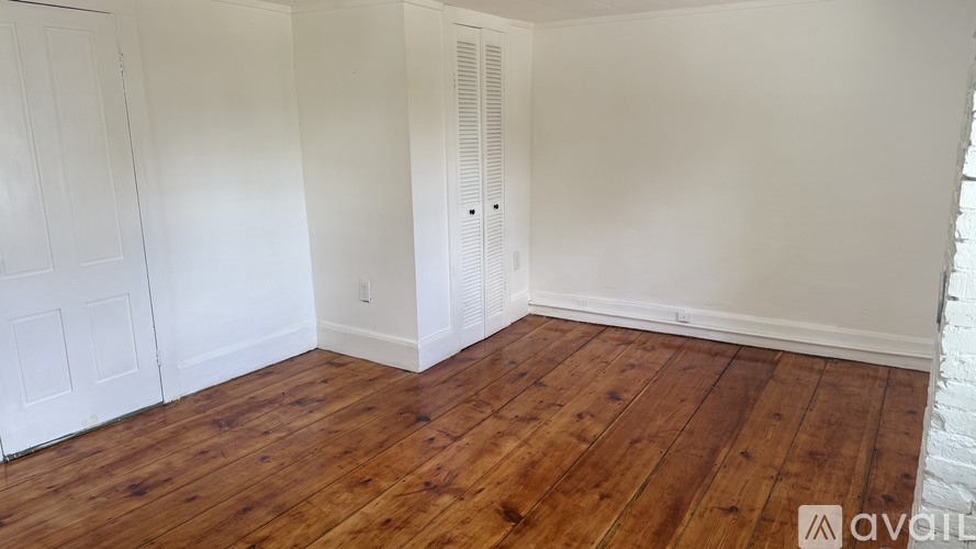 A room with wooden floors and white walls.