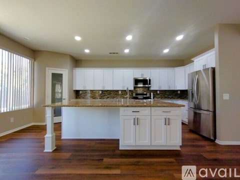 A kitchen with white cabinets and a granite countertop.