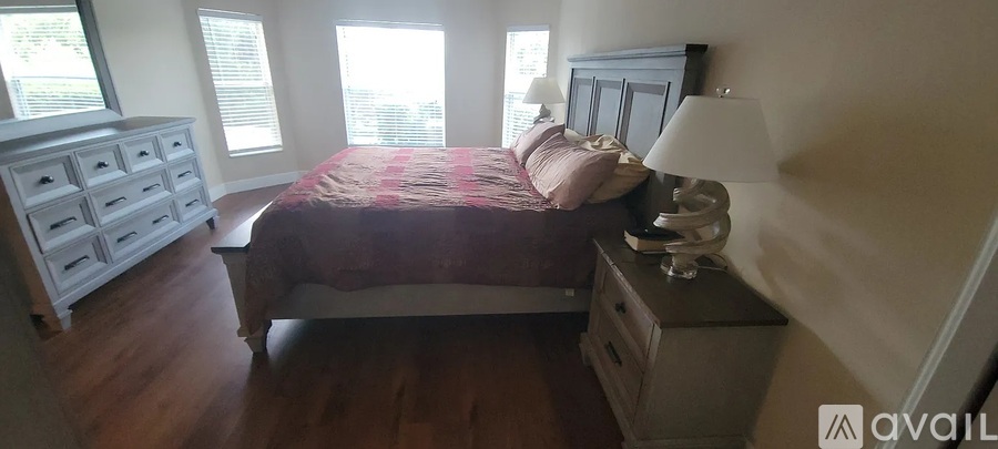 A bedroom with a bed, nightstand, and dresser.