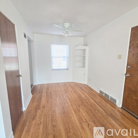 A room with wooden flooring and a ceiling fan.