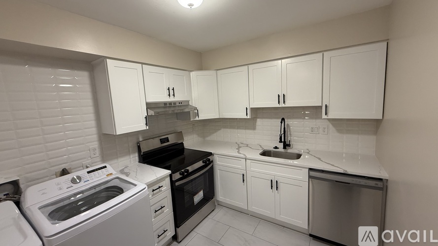 A kitchen with white cabinets and appliances.