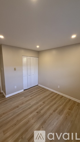 A room with wooden flooring and a white door.
